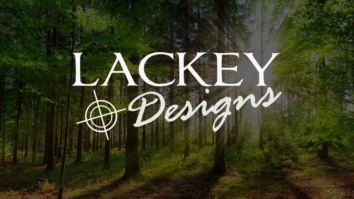 Printed homepage designs for a roofer, metal fabrication shop, plumber, landscaper and auto repair garage on a wooden desk