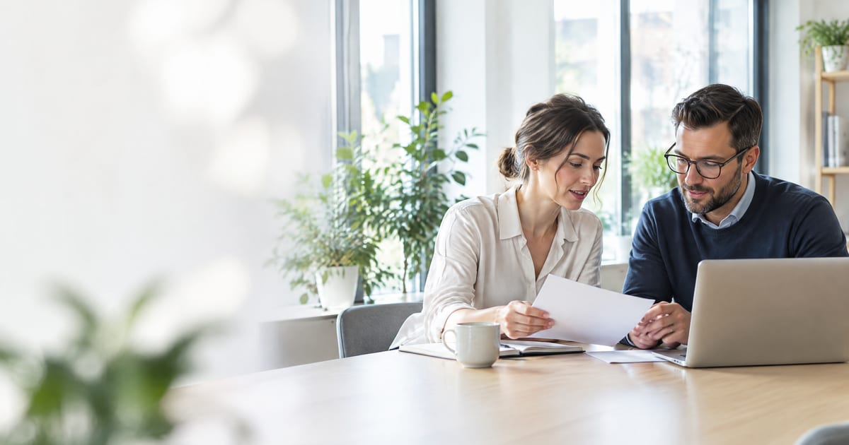 Two professionals reviewing documents at a conference table