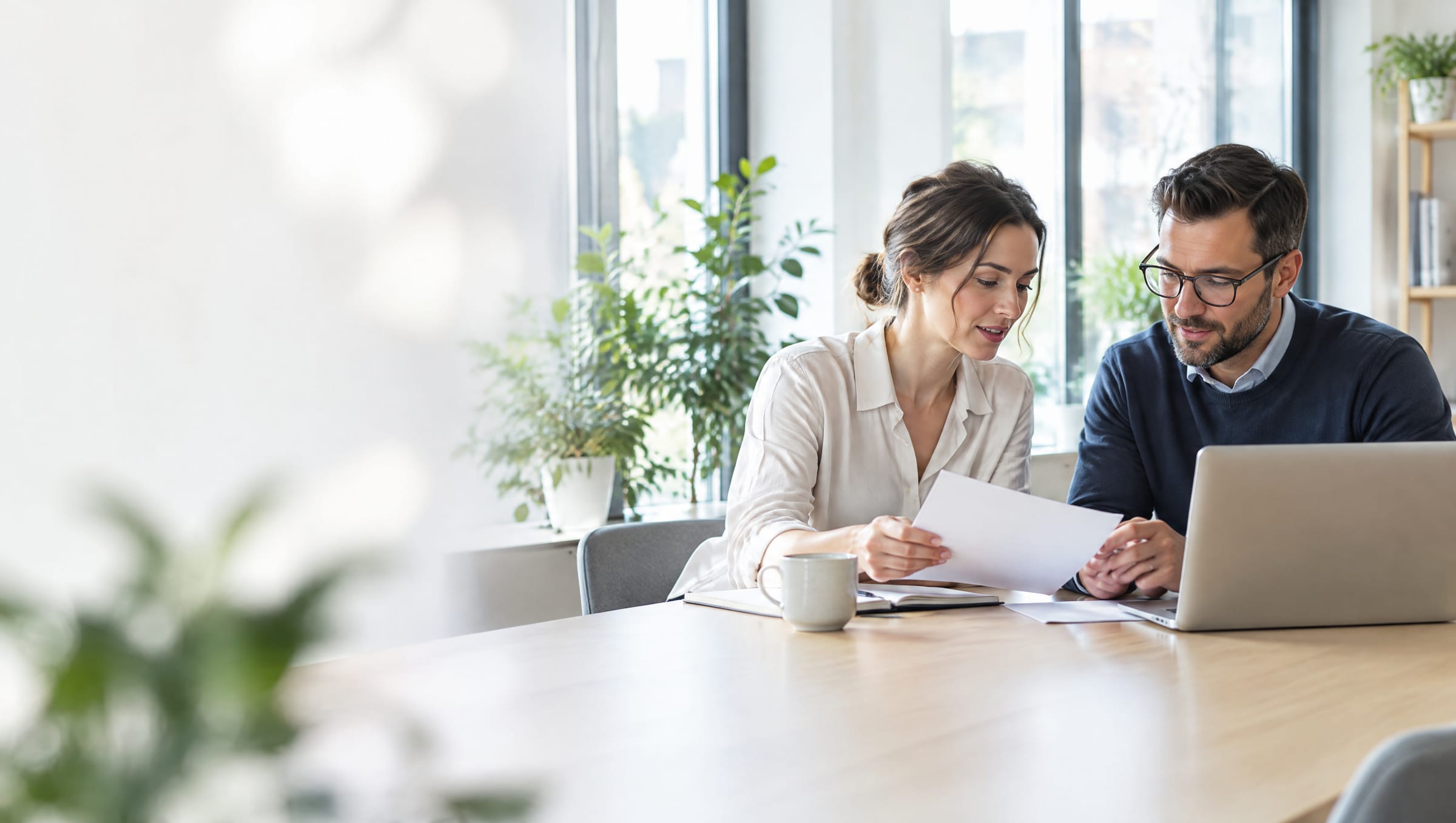 Two professionals reviewing documents at a conference table